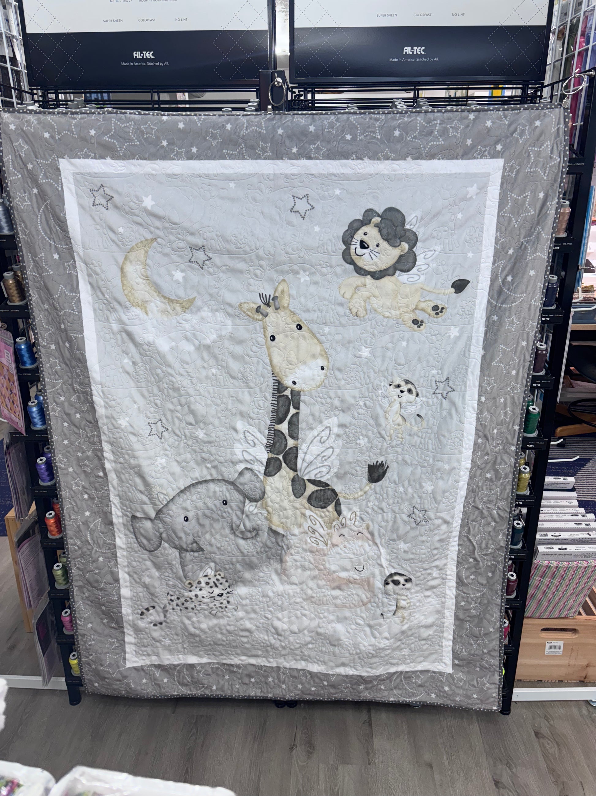 Children's quilt with animal illustrations on a rack
